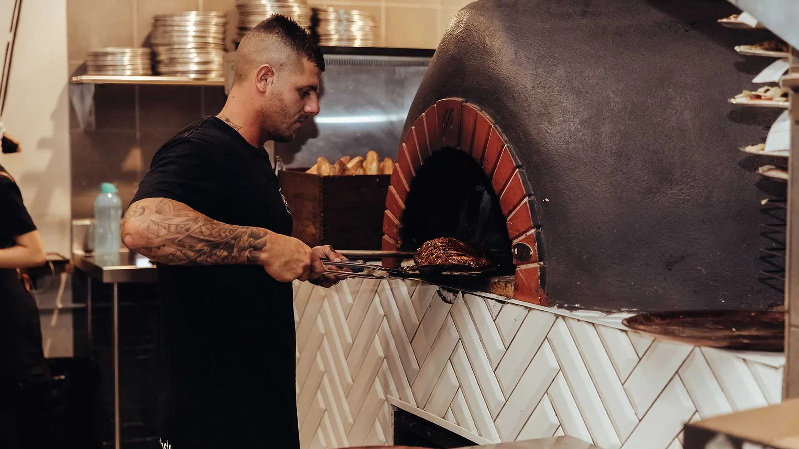 Steve firing pizzas in the woodfire oven at Flame