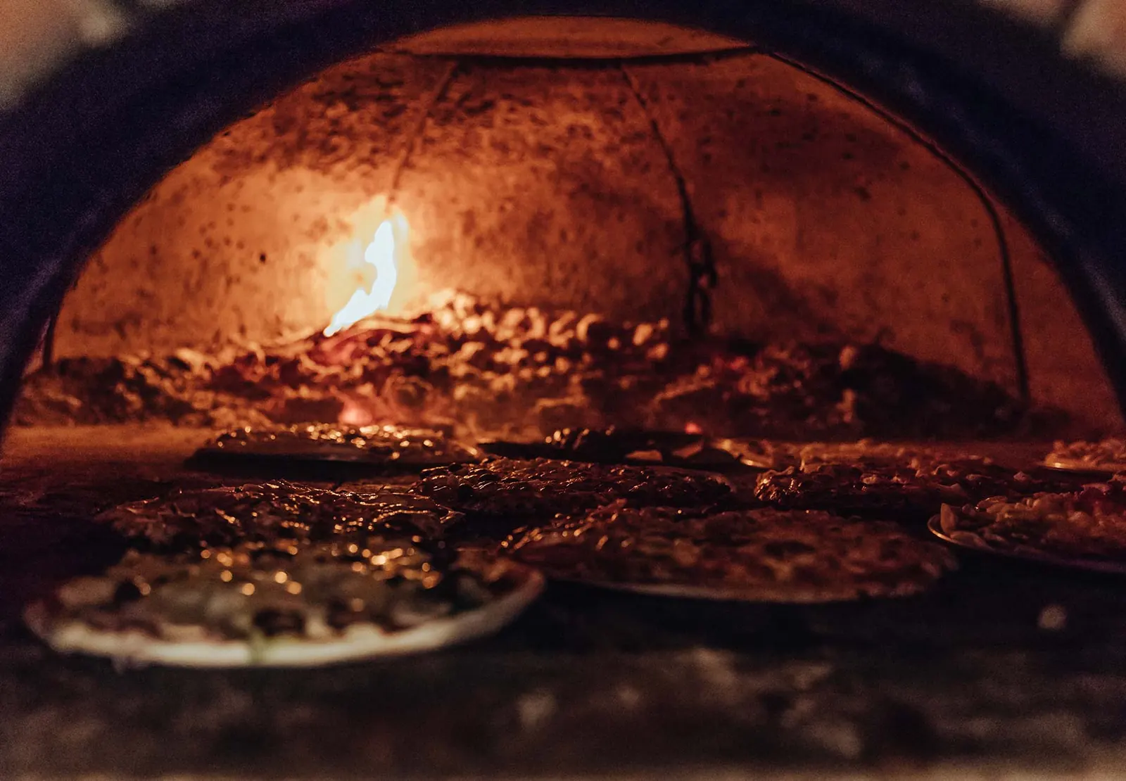 Pizzas cooking in Flame's woodfire oven